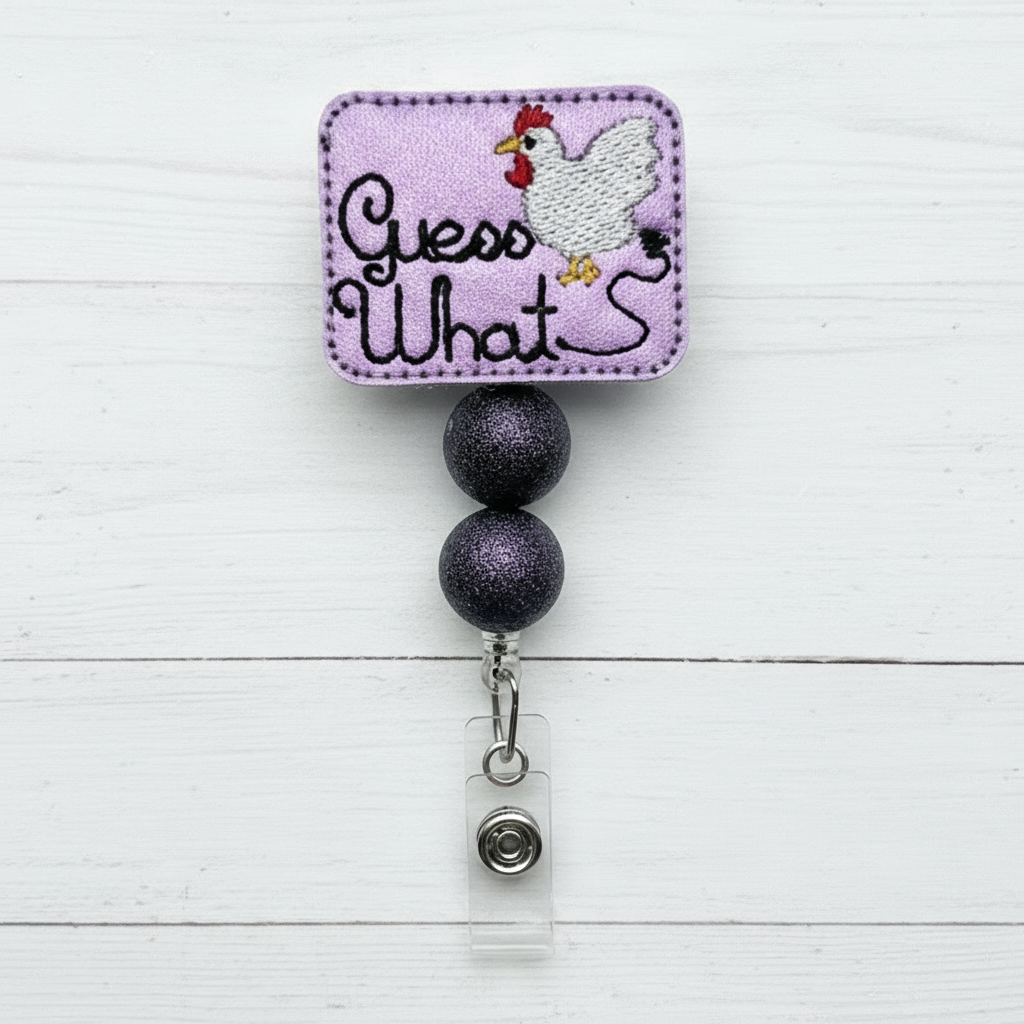 Retractable badge holder with chicken design and 'Guess What?' text on a purple background.