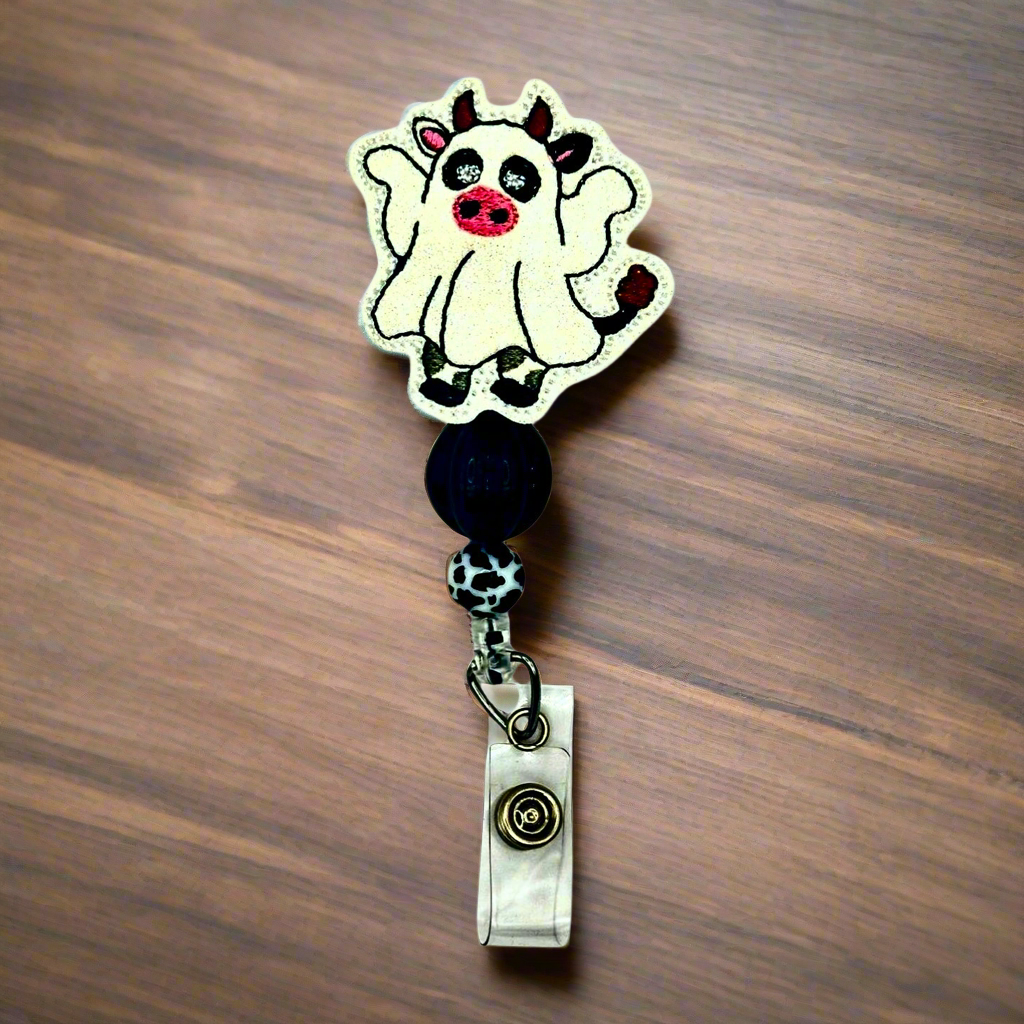 Badge holder with cartoon cow design on a wooden surface