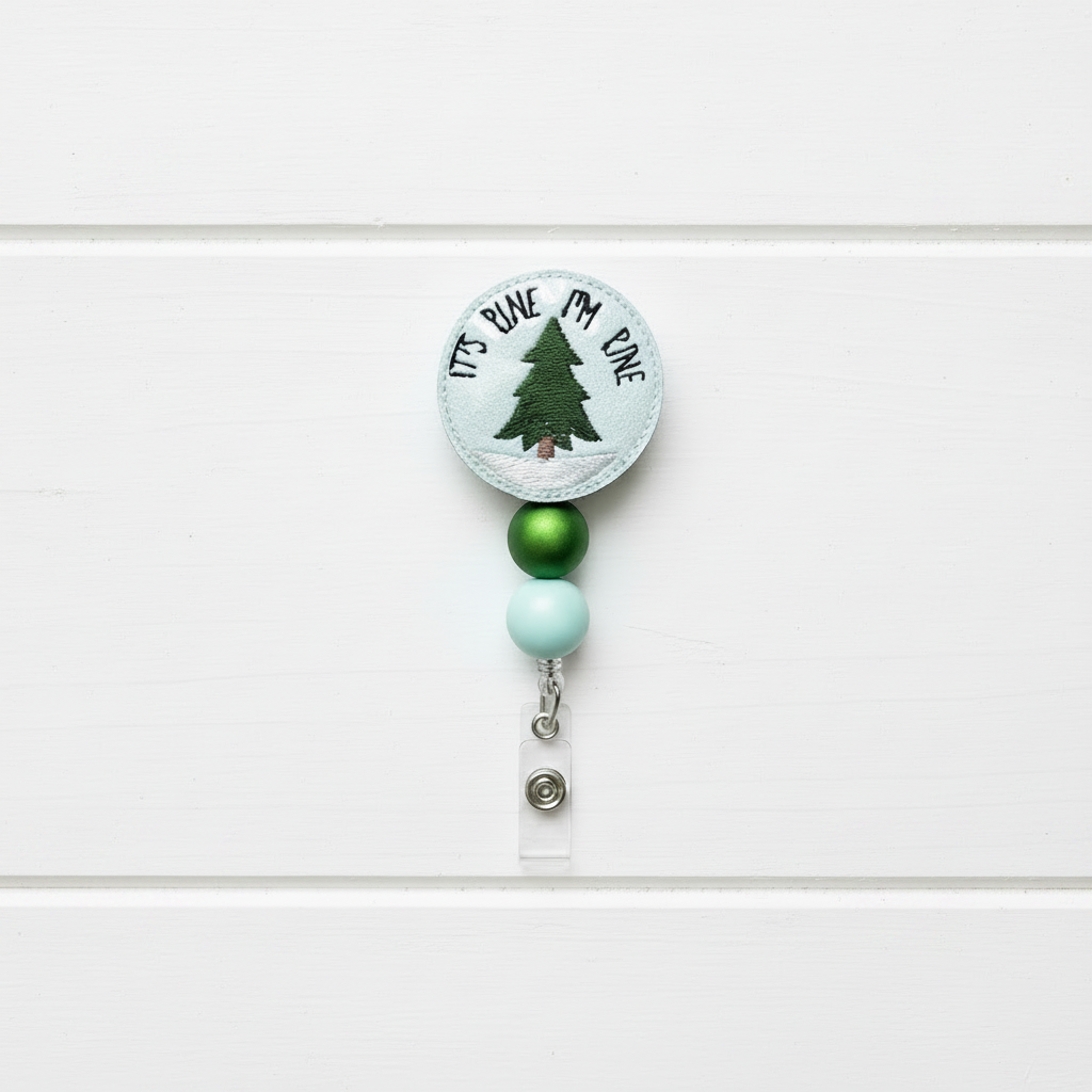 Christmas-themed badge holder with tree design on a white wooden surface with festive decorations.