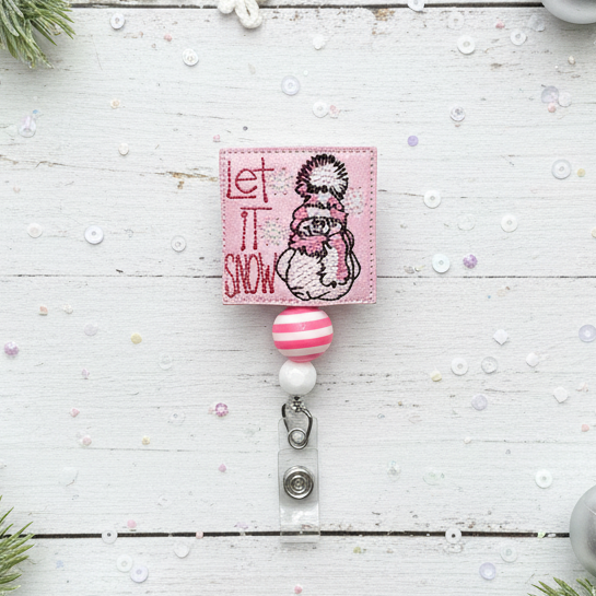 Retractable badge holder with snowman design and 'Let It Snow' text on a white background