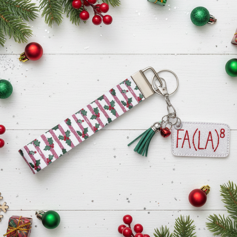 Christmas-themed keychain with 'FA(LA)8' tag on a festive background with ornaments and holly.