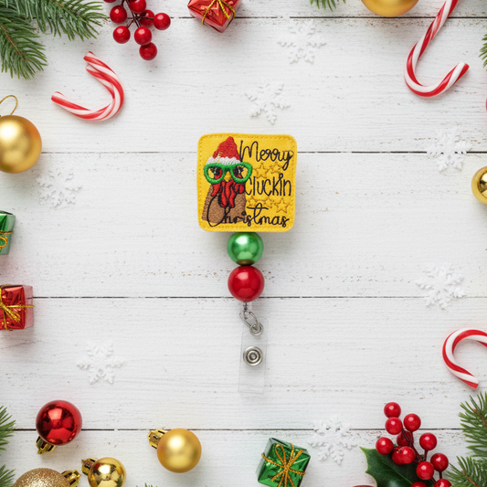 Decorative badge with 'Merry Cluckin Christmas' text surrounded by Christmas ornaments on a white wooden background.