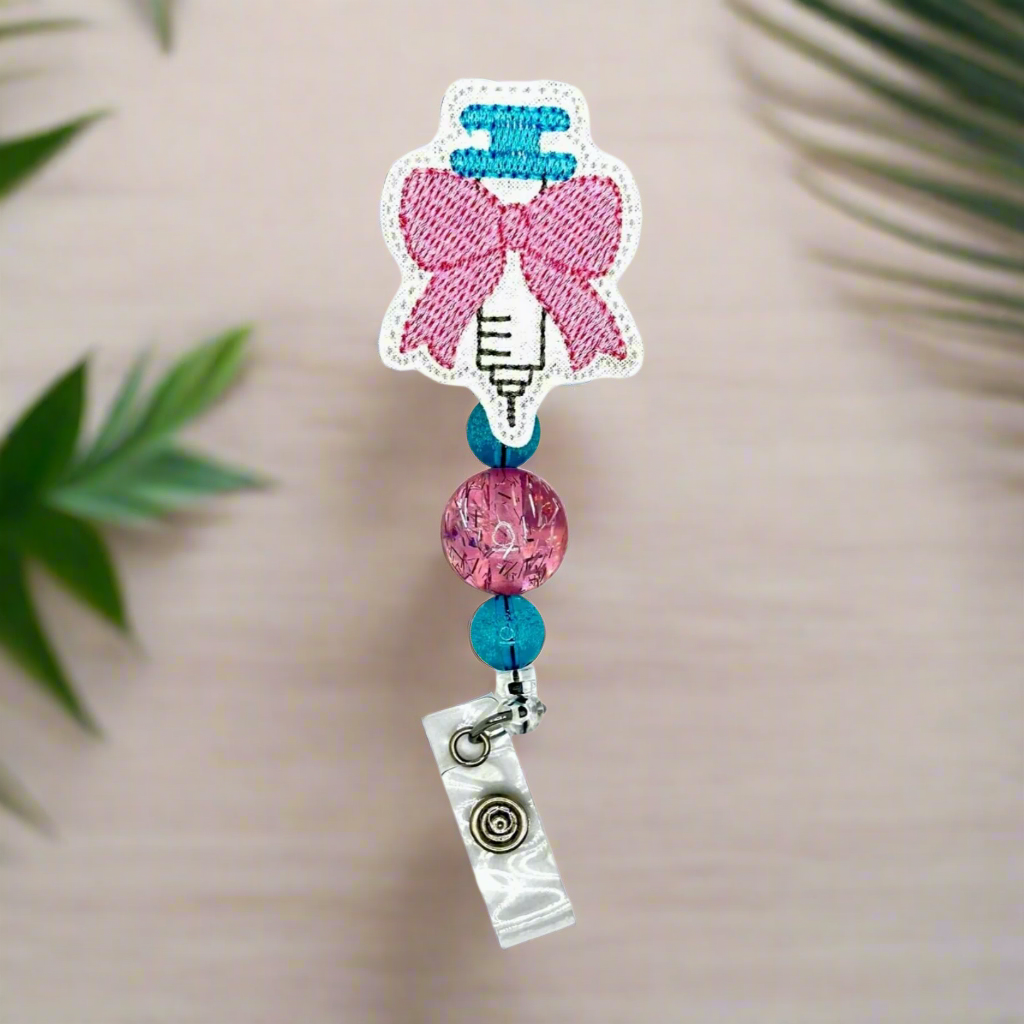 Syringe with bow badge reel