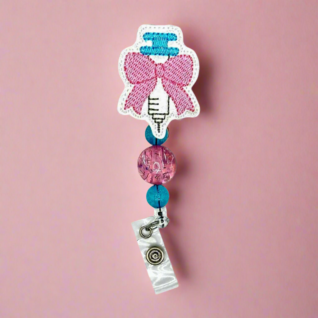 Syringe with bow badge reel
