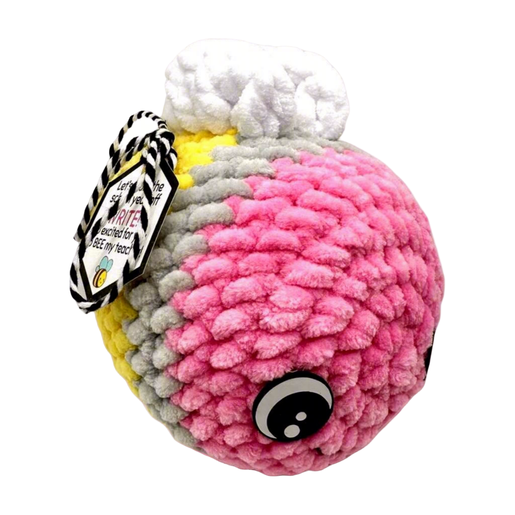 A plush toy resembling a bee, primarily in shades of pink and white, with a tag attached that reads 'Pencil Bee Plushie'.