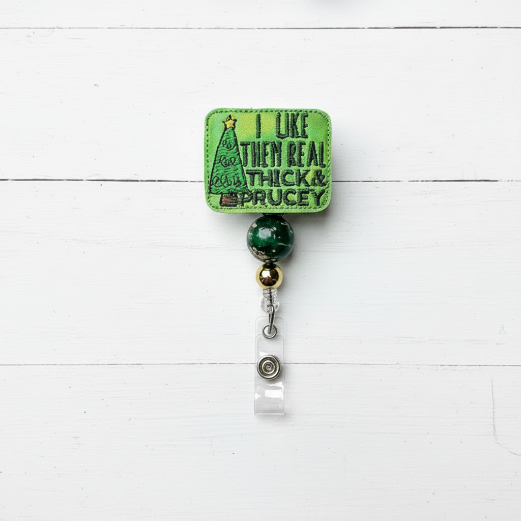 Green badge holder with Christmas tree design and text on a white wooden background with festive decorations.