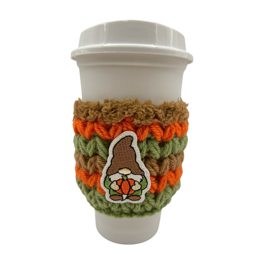 Cup with a knitted sleeve featuring a gnome design on a white background