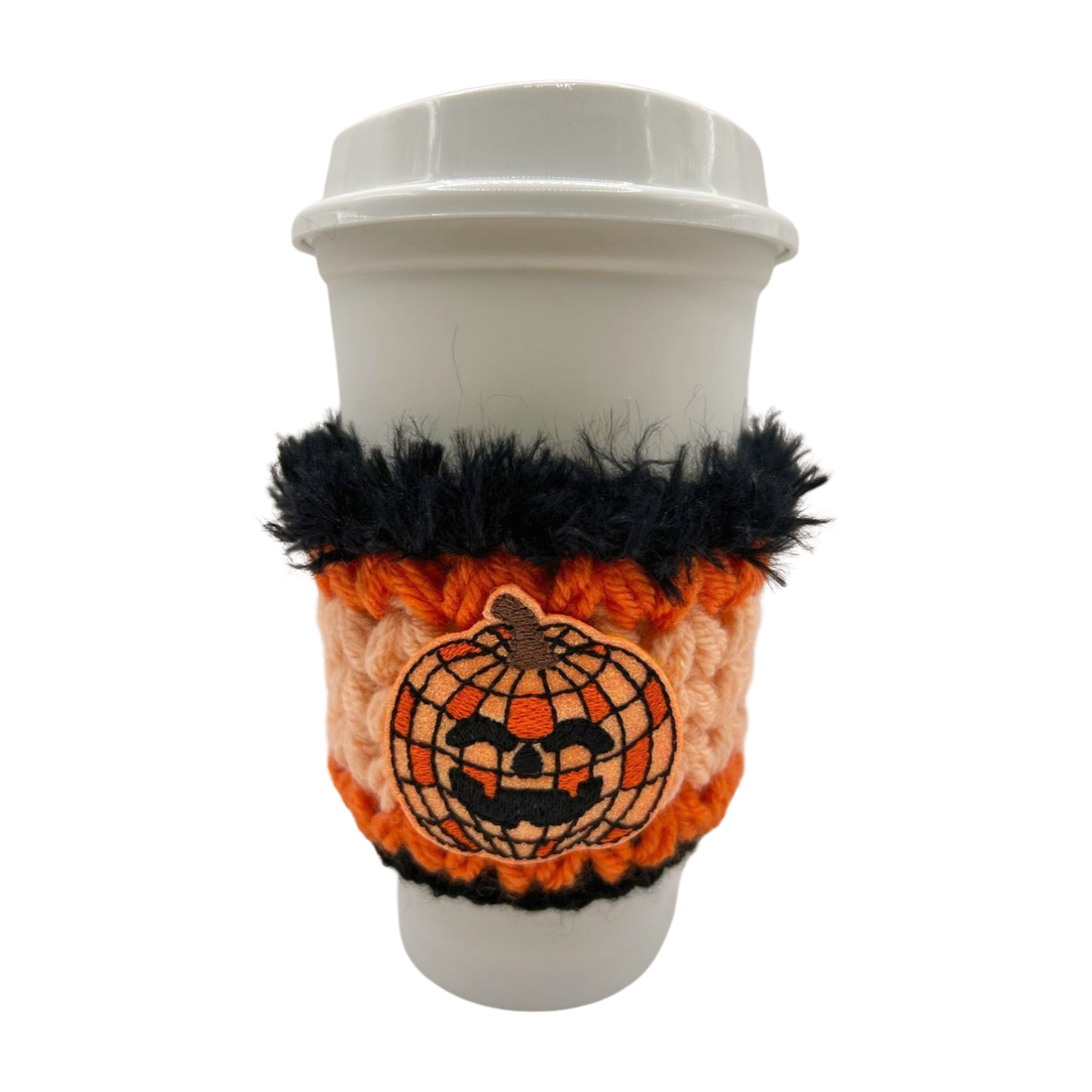 Coffee cup with an orange and black Halloween-themed cozy on a white background