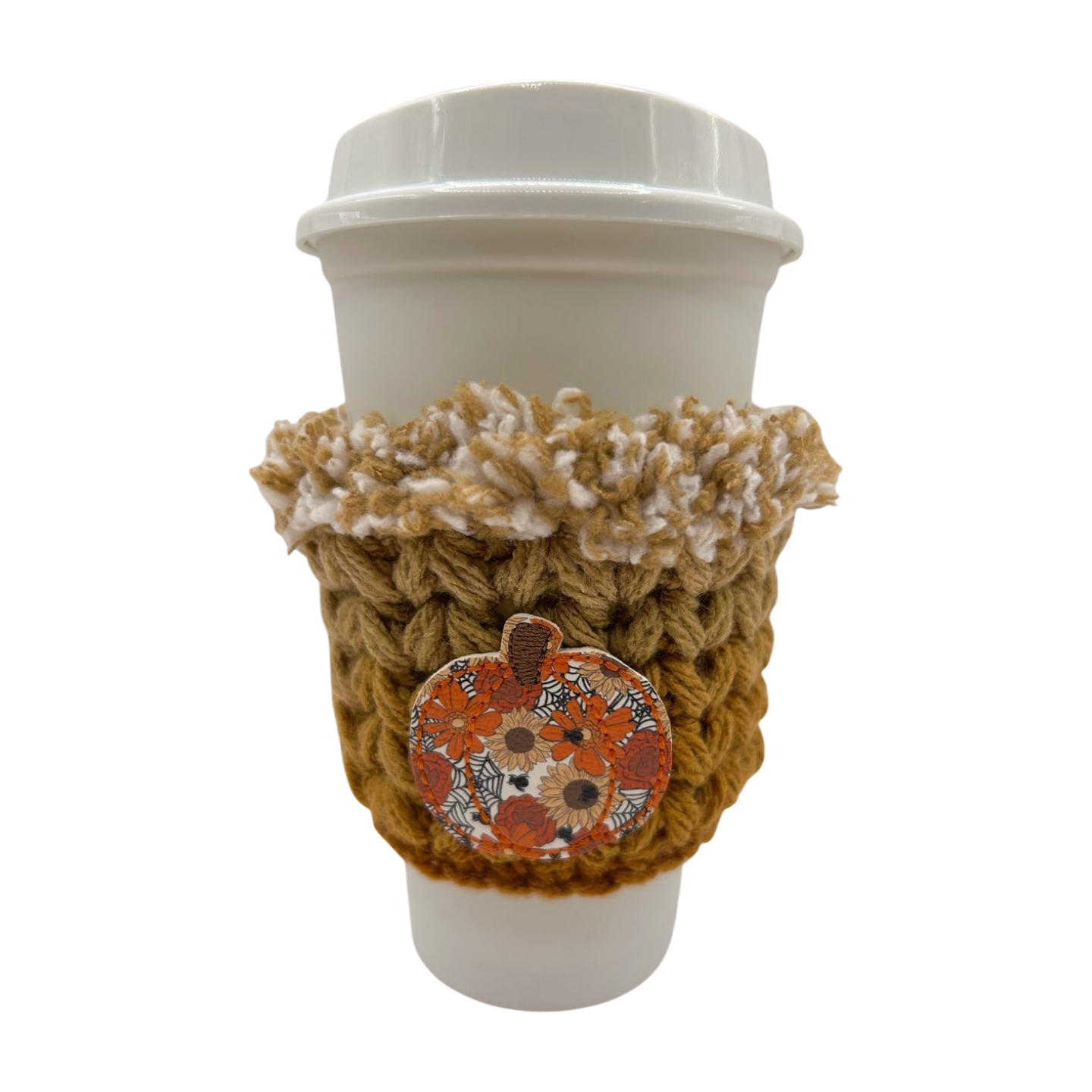 Coffee cup with a brown crochet cozy featuring a pumpkin design on a white background