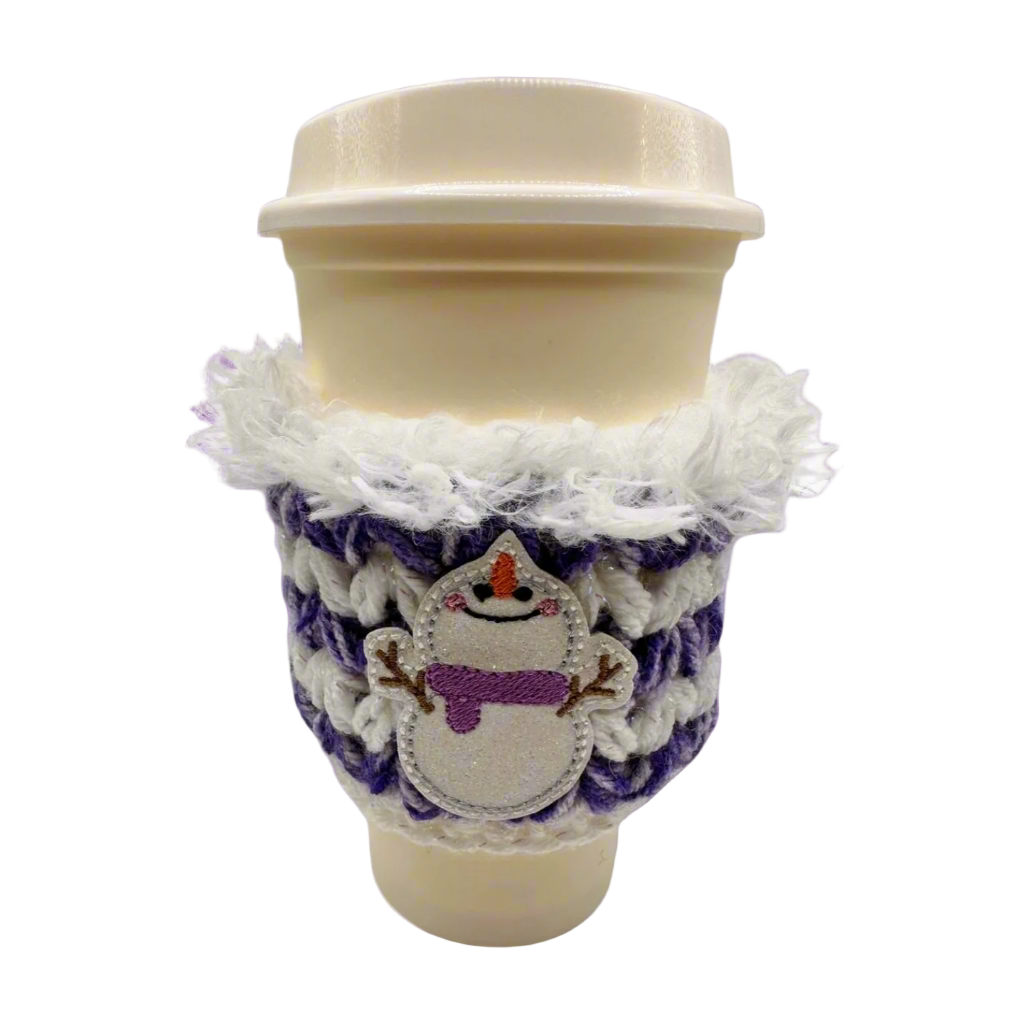 A coffee cozy sleeve with a snowman design, primarily in blue and gray tones, wrapped around a coffee cup.