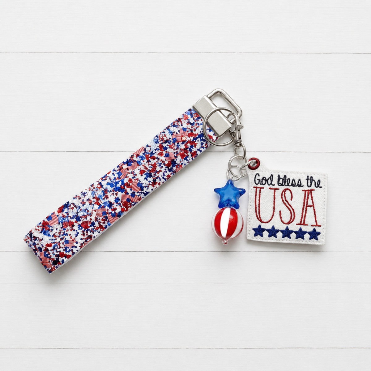 God Bless The USA Keychain and Wristlet — clean white wood primary image