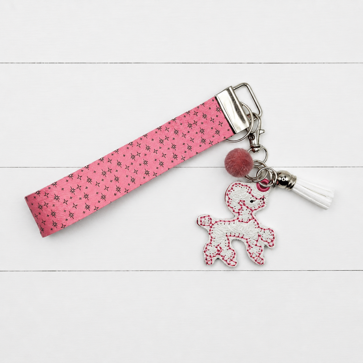 Pink Poodle Keychain and Wristlet on clean white wood background