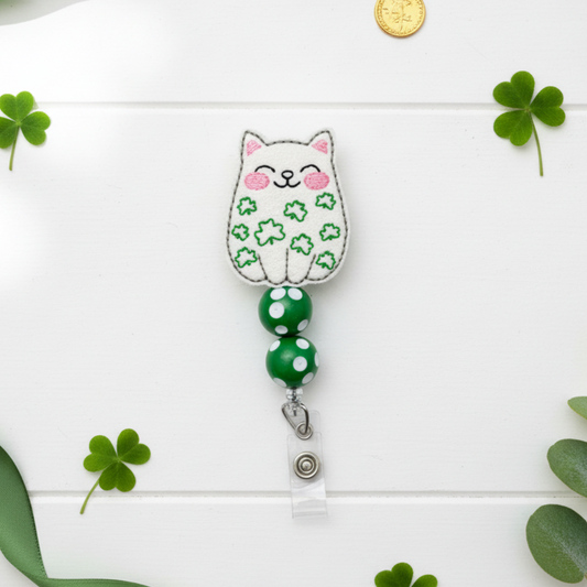 Cat-shaped badge holder with green polka dot ribbon on a white background