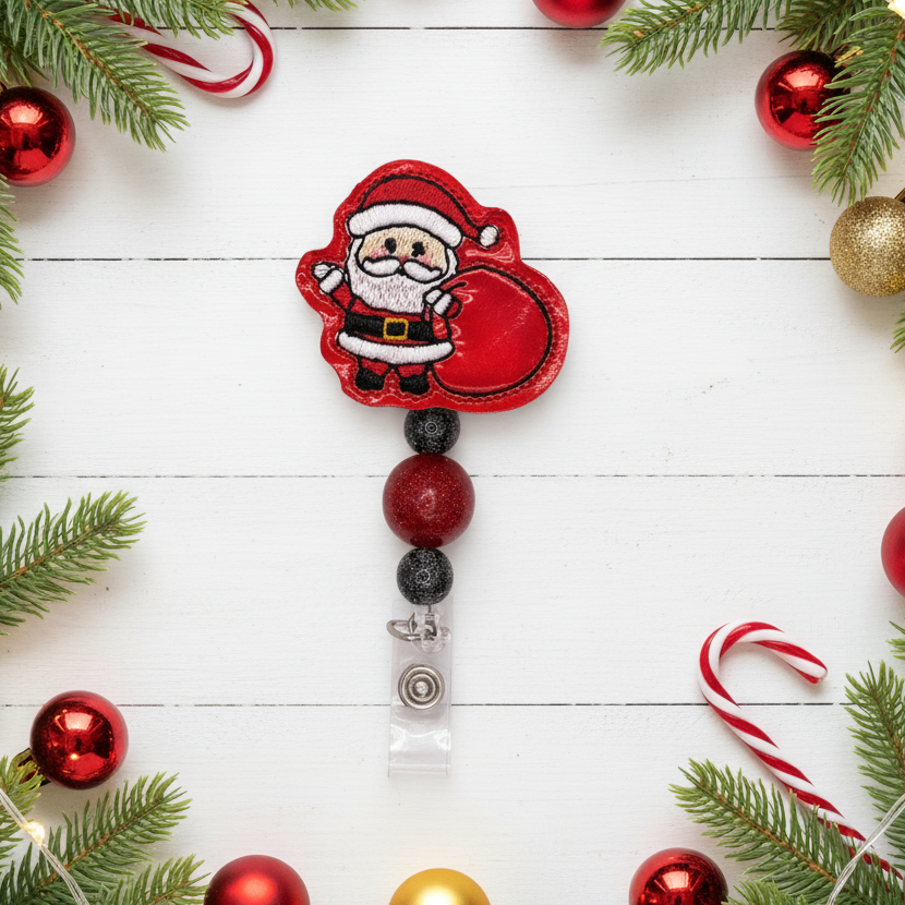 Decorative keychain with Santa Claus design on a white wooden background with Christmas decorations.