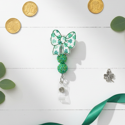Green and white decorative badge holder with a bow and beads on a white background