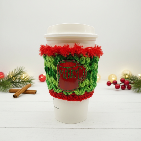 Crocheted cup sleeve with red and green pattern on a white background