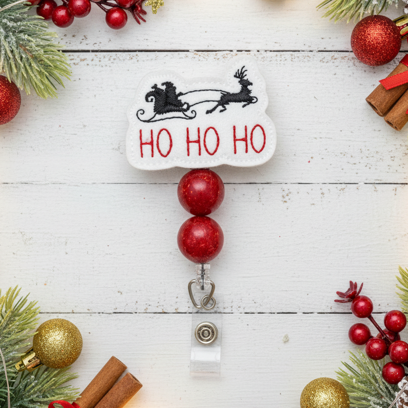 Christmas-themed badge holder with 'HO HO HO' text and reindeer design on a white wooden background with festive decorations.