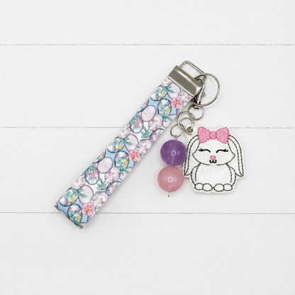 Bunny with Bow Keychain and Wristlet on clean white painted wood background