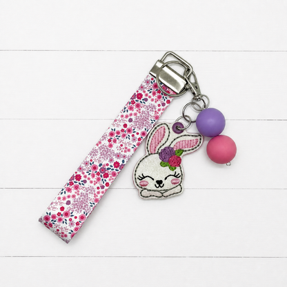 Bunny with Flowers Keychain and Wristlet on clean white painted wood background