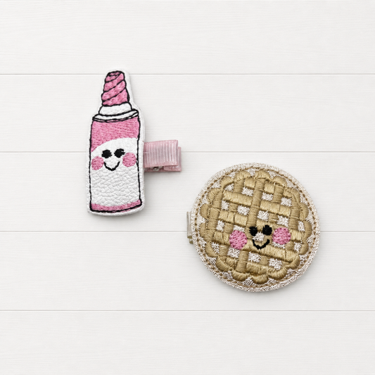 Pie and whip cream hair clip on a clean white wood background