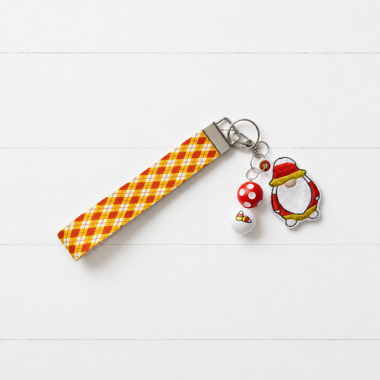 Candy Corn Gnome Keychain and Wristlet on clean white painted wood background