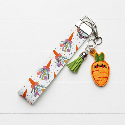 Carrot Bunny Keychain and Wristlet on clean white painted wood background