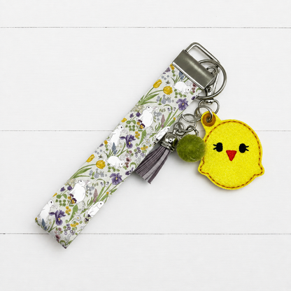 Chick Keychain and Wristlet on clean white painted wood background