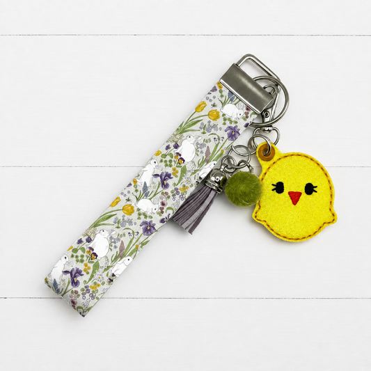 Chick Keychain and Wristlet on clean white painted wood background