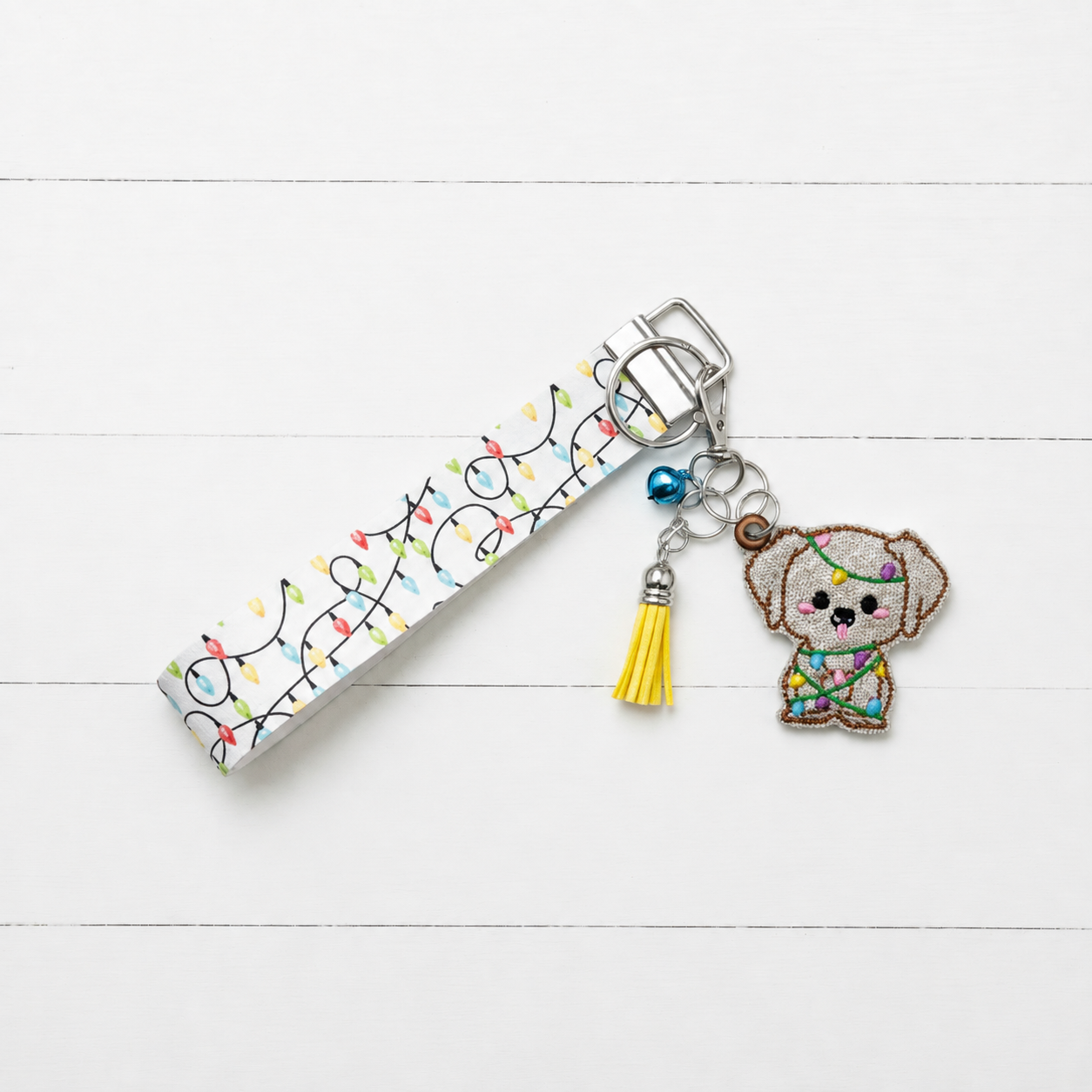Christmas Light Puppy Keychain and Wristlet on clean white painted wood background
