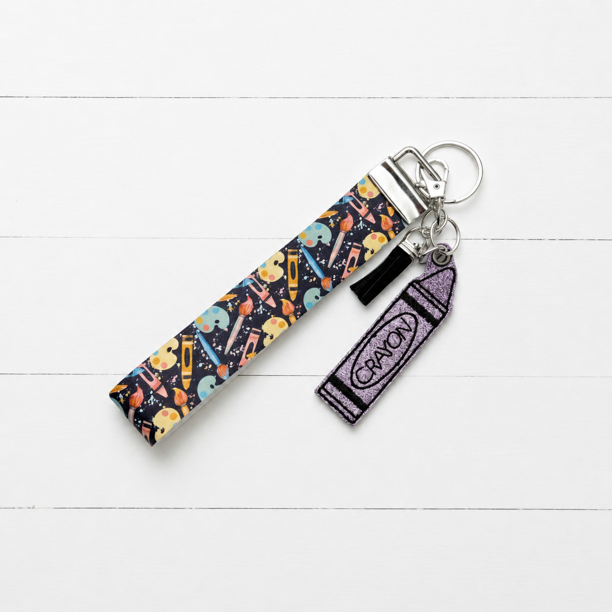 Crayon Keychain and Wristlet on clean white painted wood background