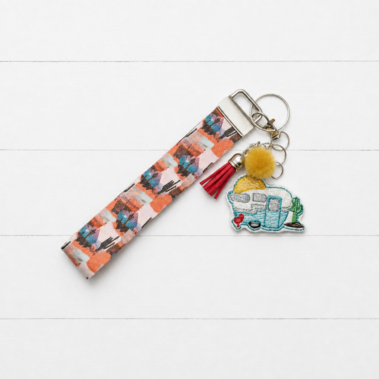 Desert Camper Keychain and Wristlet on clean white painted wood background