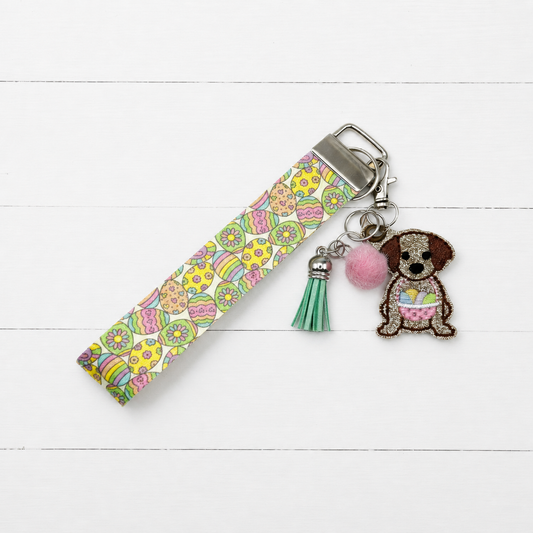 Dog with Easter Basket Keychain and Wristlet on clean white painted wood background
