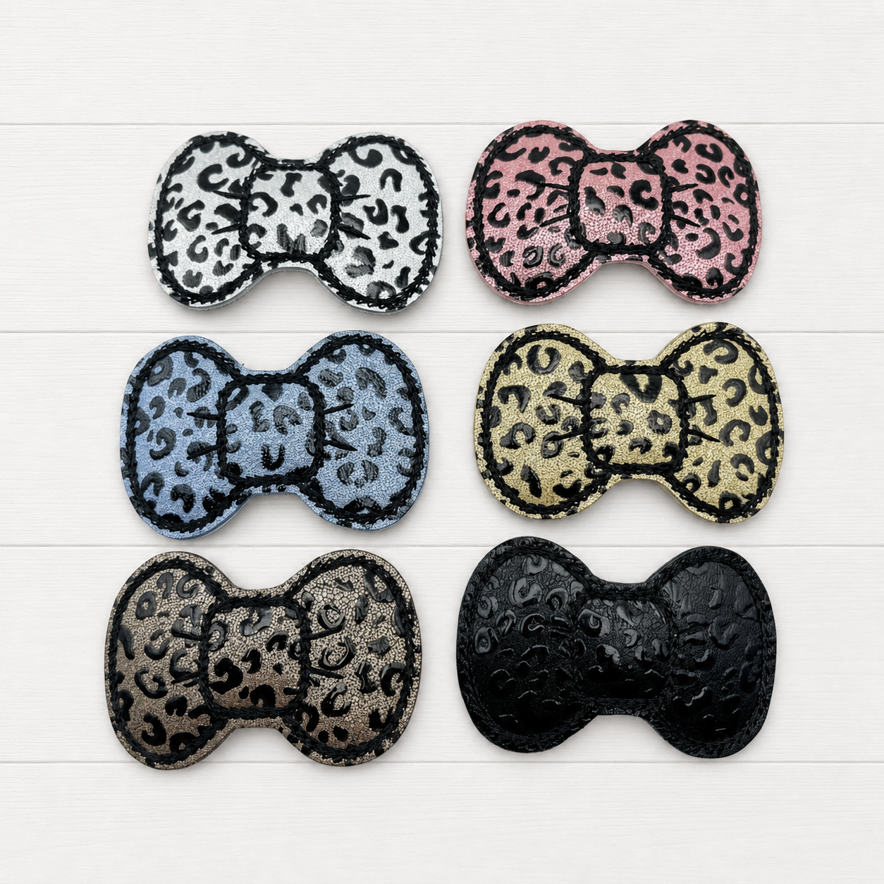 Leopard Hair Bow Clips on a clean white wood background