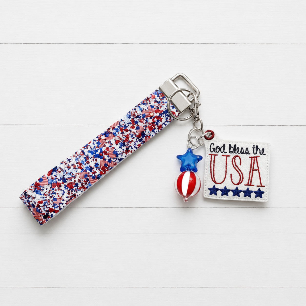 God Bless The USA Keychain and Wristlet — clean white wood primary image