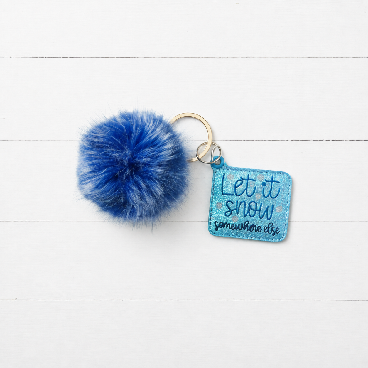 Let it Snow Somewhere Else Pom Pom Keychain — clean white wood primary image