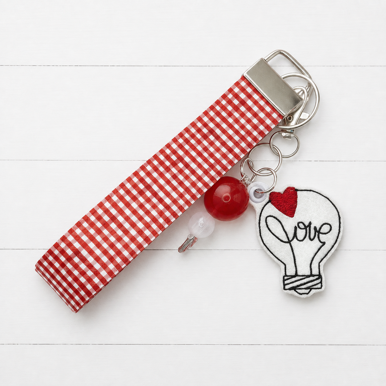 Love Lightbulb Keychain and Wristlet — clean white wood primary image