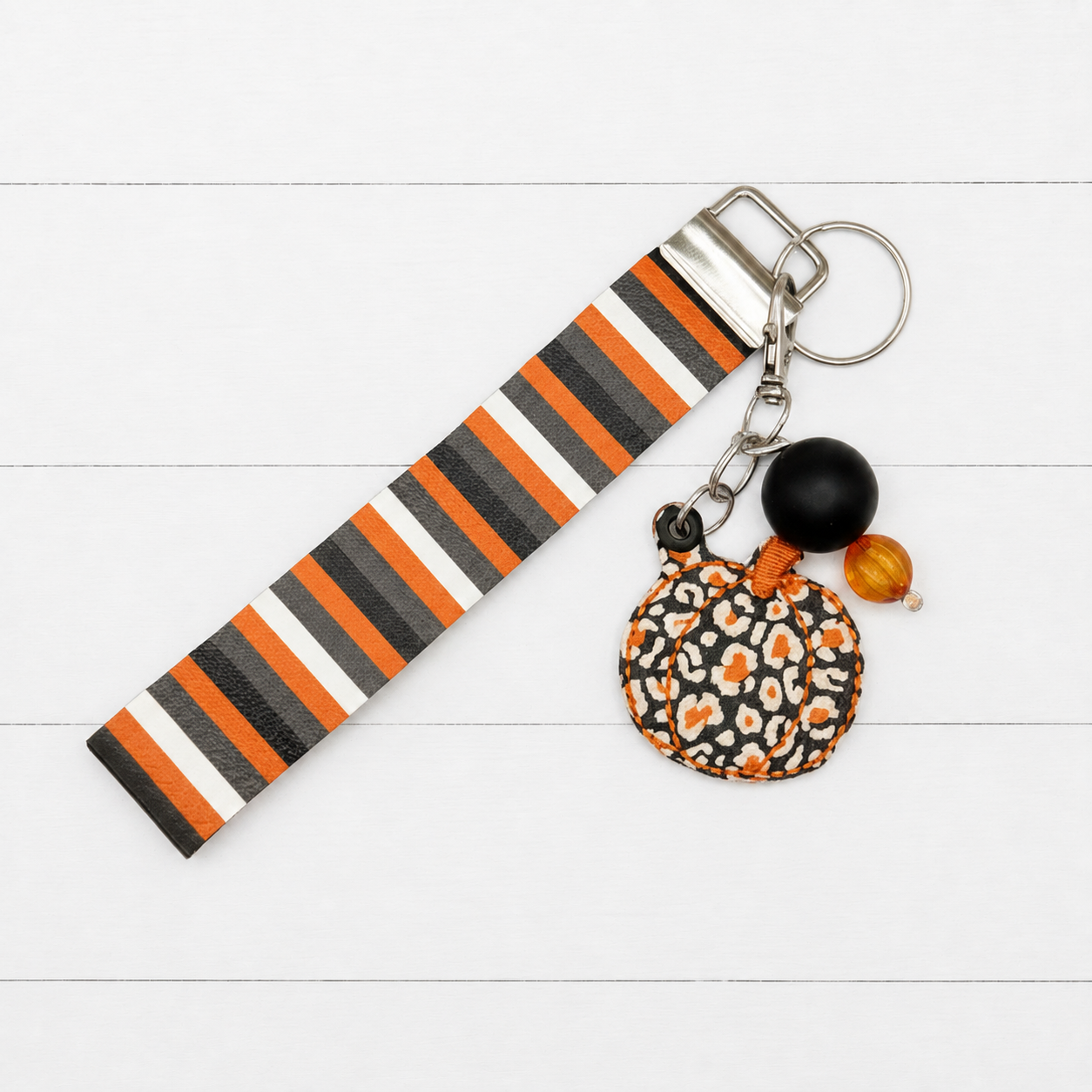 Orange Leopard Pumpkin Keychain and Wristlet on clean white wood background