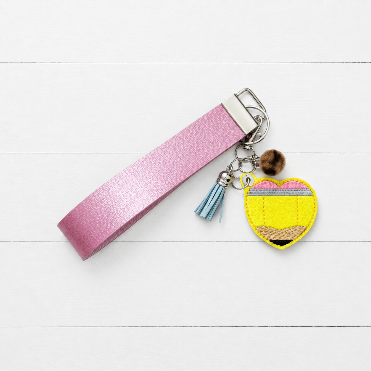 Pencil Heart Keychain and Wristlet on clean white wood background