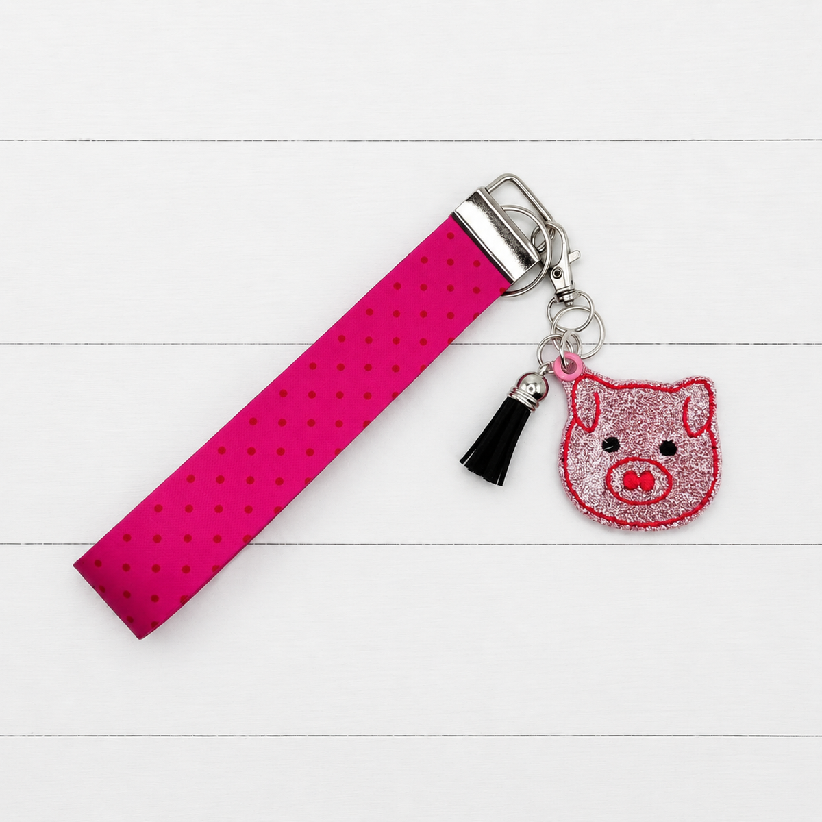 Pig Head Keychain and Wristlet on clean white wood background