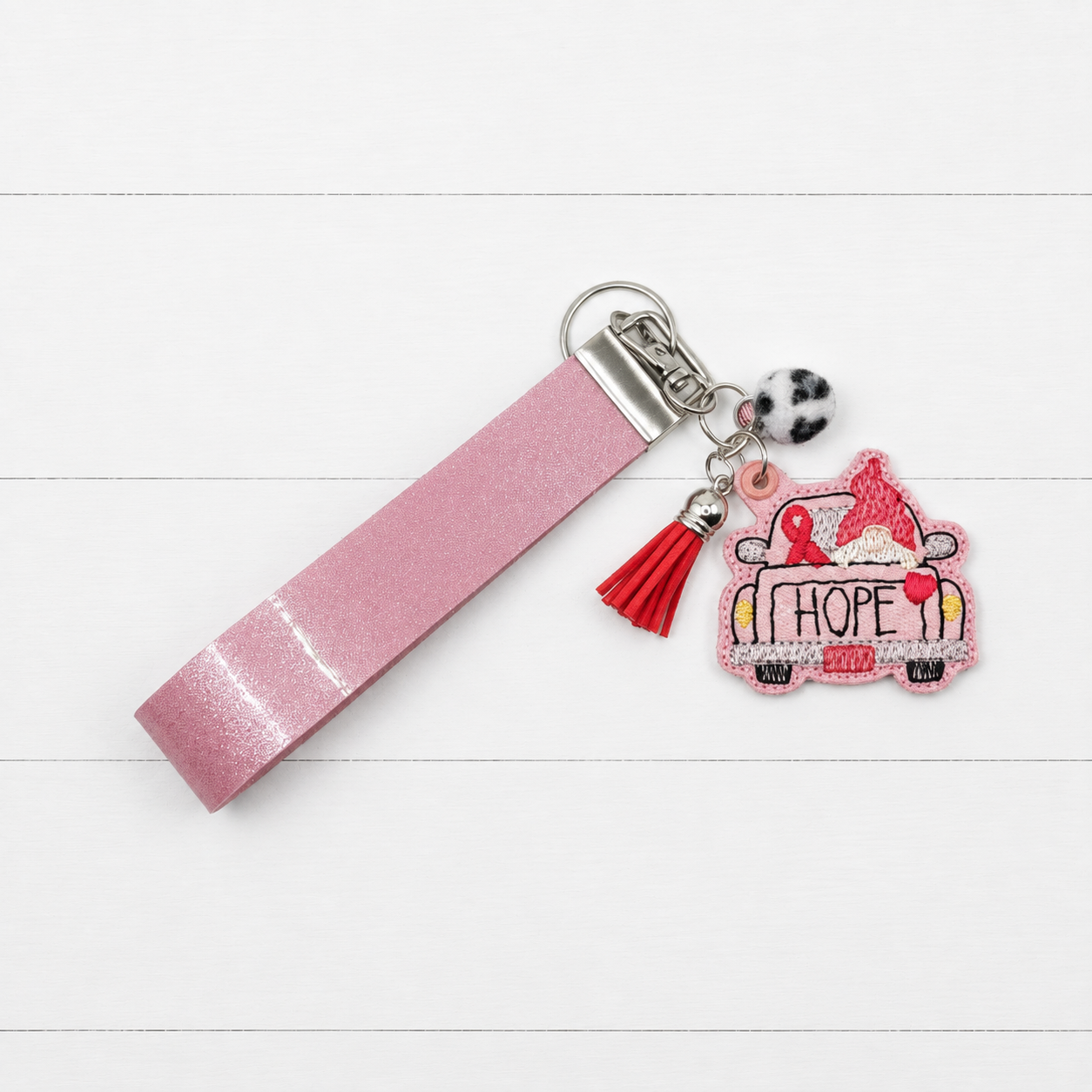 Pink Gnome Hope Truck Keychain and Wristlet on clean white wood background