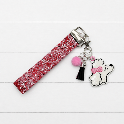 Poodle Head Keychain and Wristlet on clean white wood background