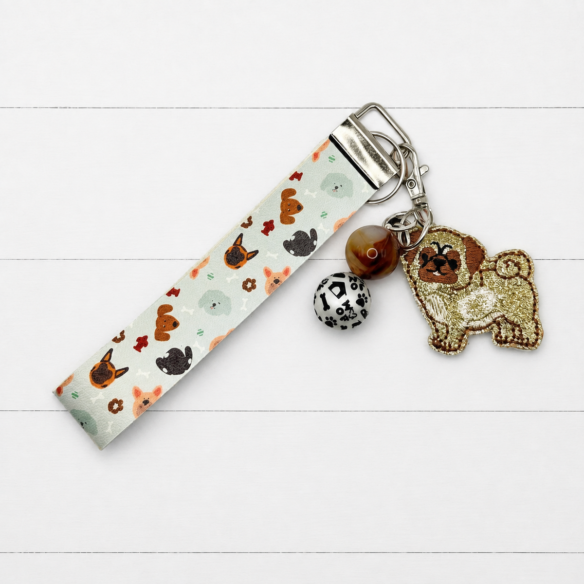 Pug Keychain and Wristlet on clean white wood background