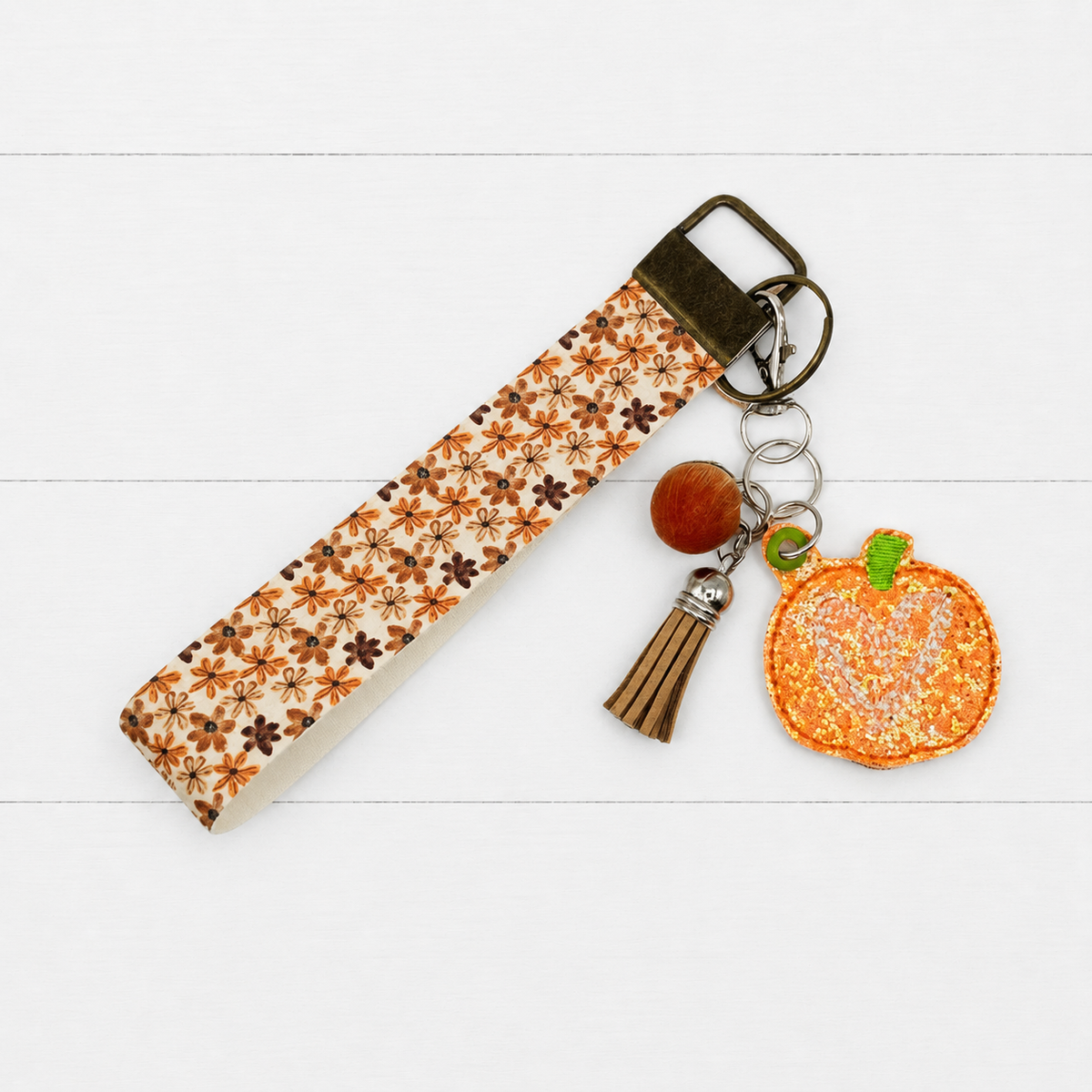 Pumpkin Heart Keychain and Wristlet on clean white wood background