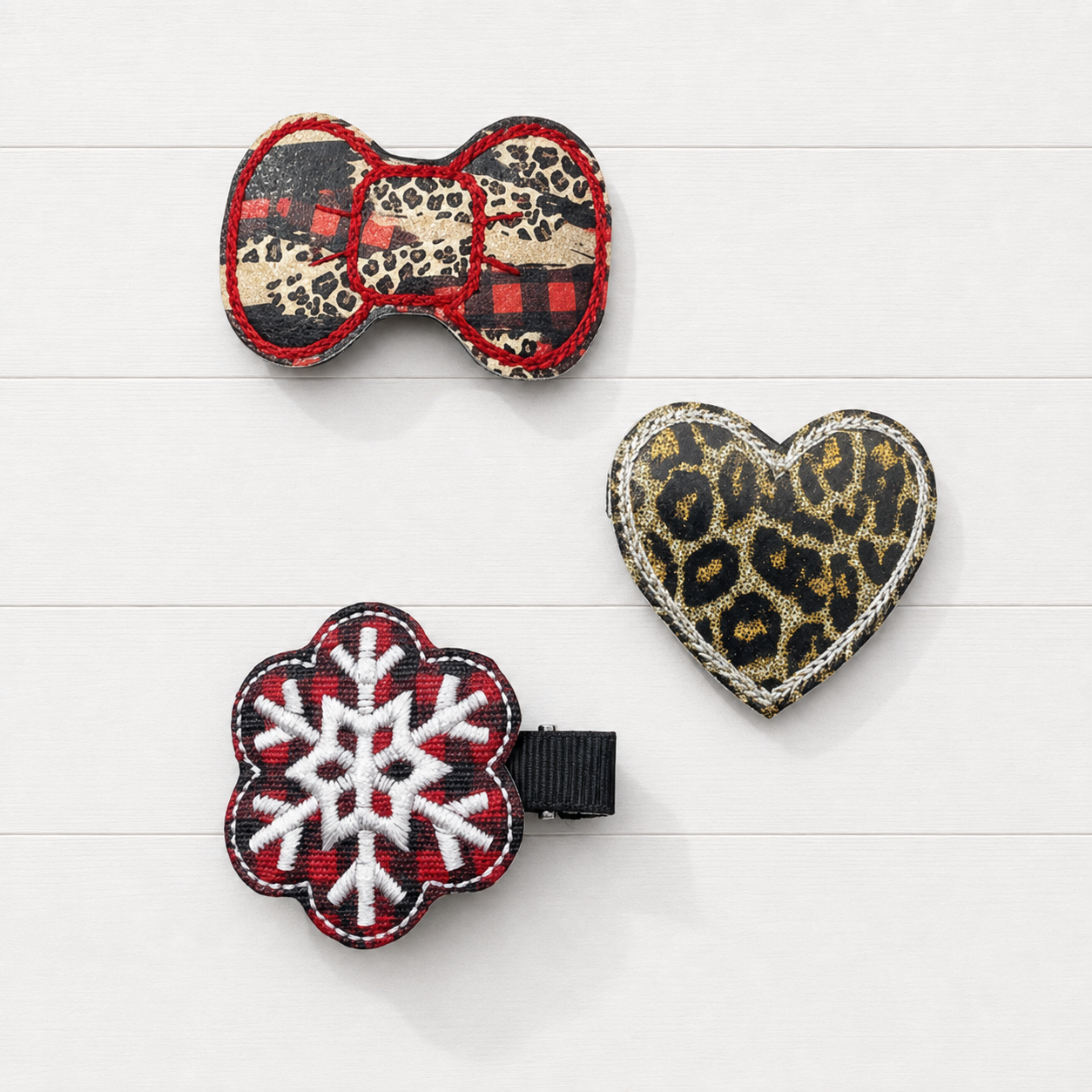 Leopard and plaid winter hair clip set on a clean white wood background