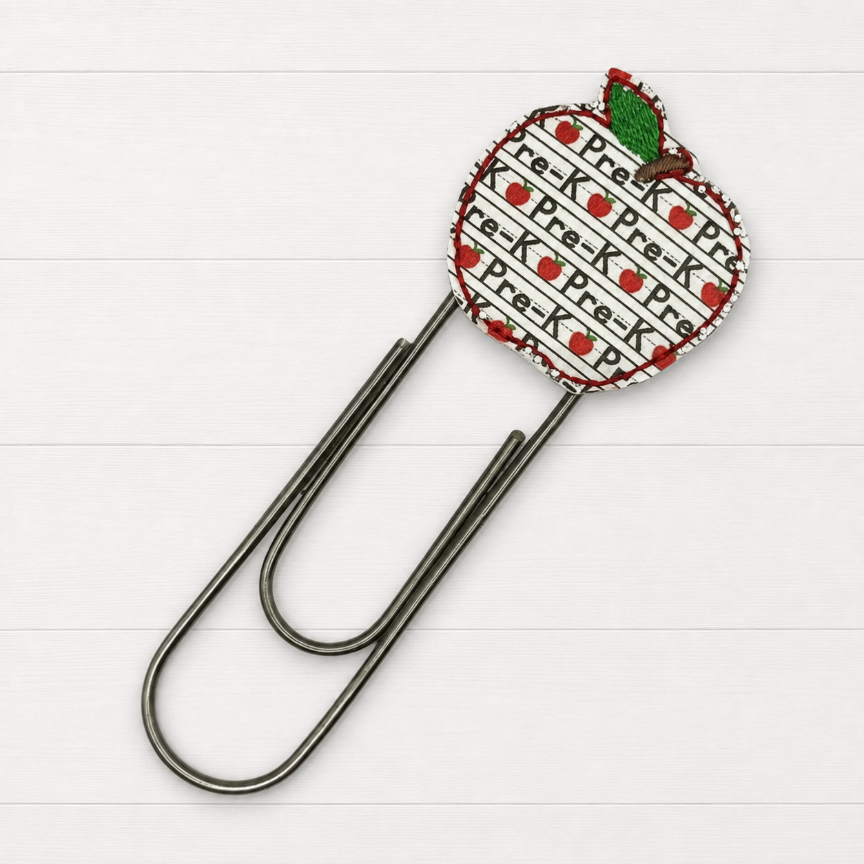 Pre K Oversized Paperclip on a clean white wood background