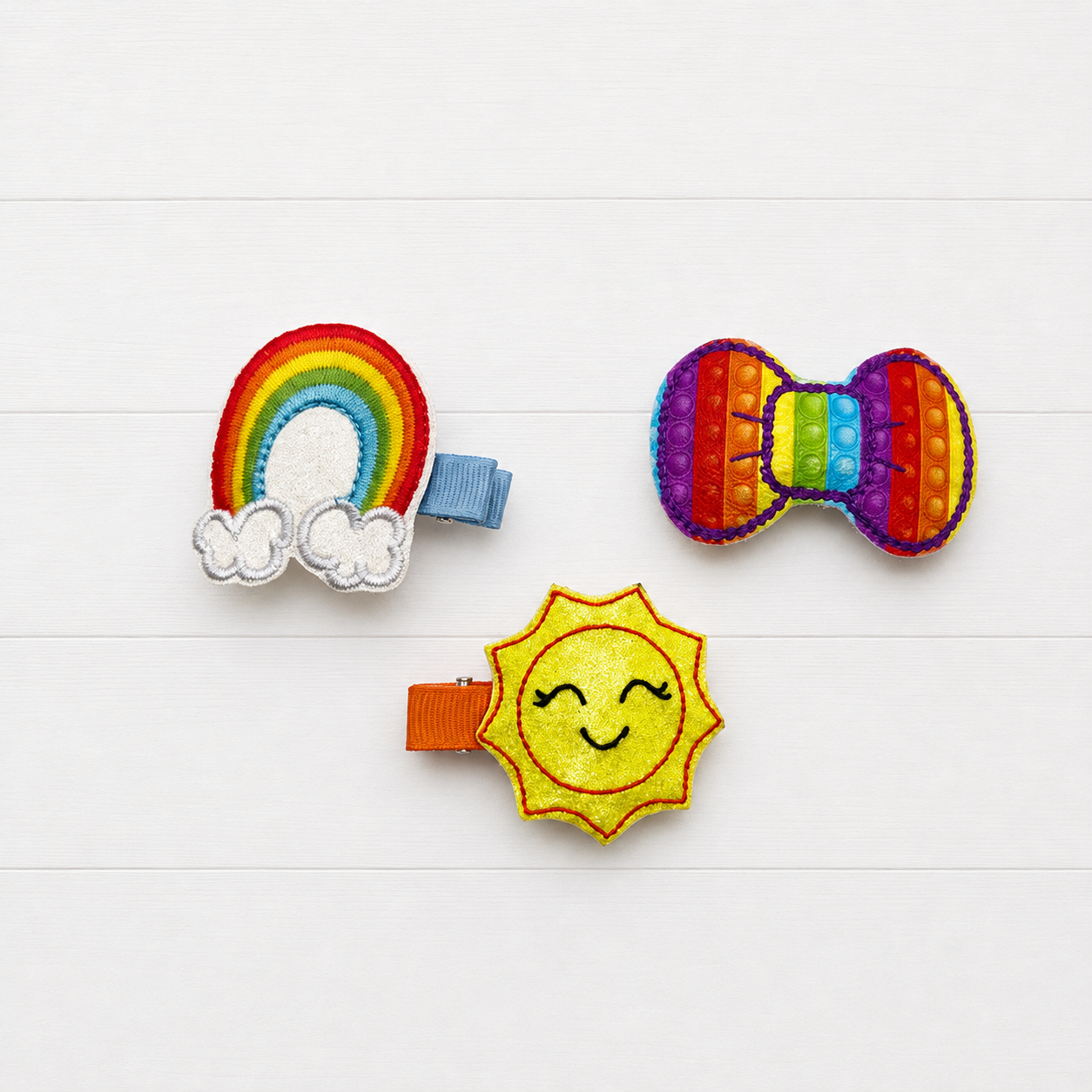 Rainbow and Sun Hair Clip Set on a clean white wood background