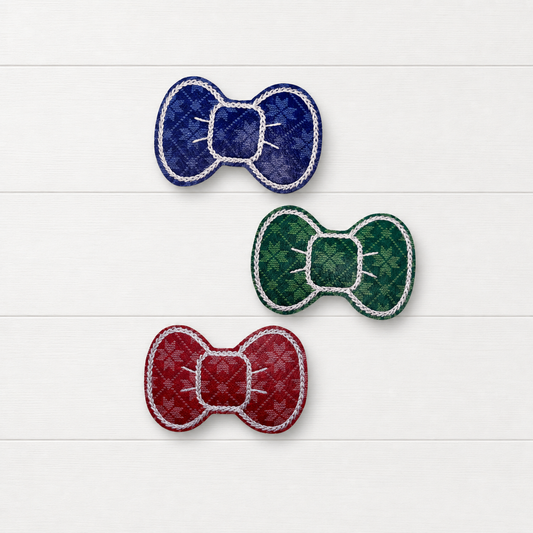 Red, blue and green snowflake sweater Christmas hair clip set on a clean white wood background