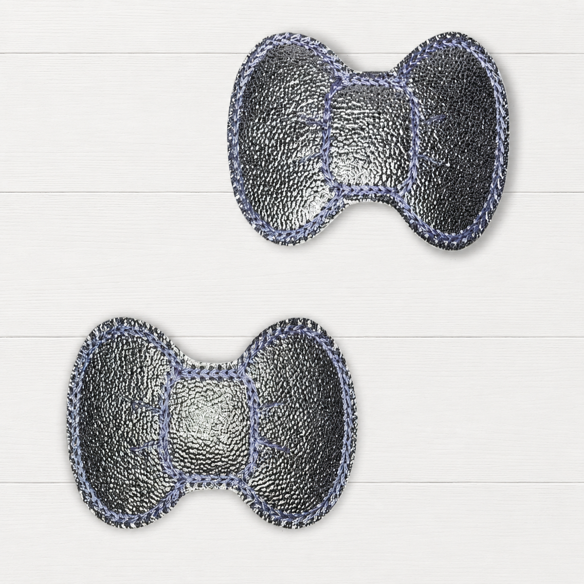 Silver hair clips on a clean white wood background