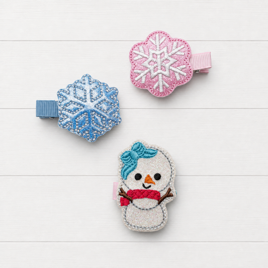 Snow girl and snow flakes hair clip set on a clean white wood background